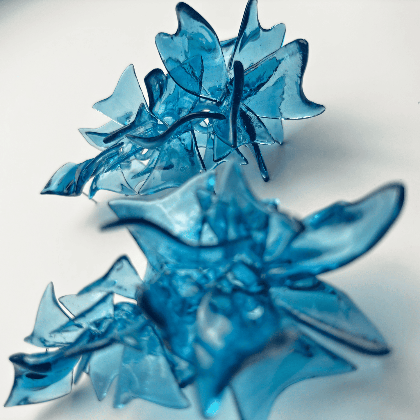 Blue sculptural jewelry pieces with abstract petal shapes on white, Eclipse Element