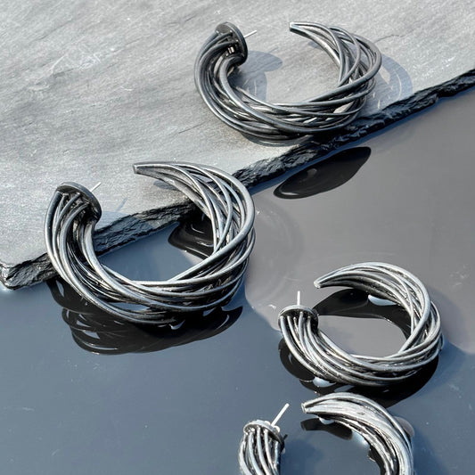 Angled view of black sculpted hoop earrings, emphasizing the 3D-printed texture