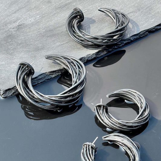 Angled view of black sculpted hoop earrings, emphasizing the 3D-printed texture