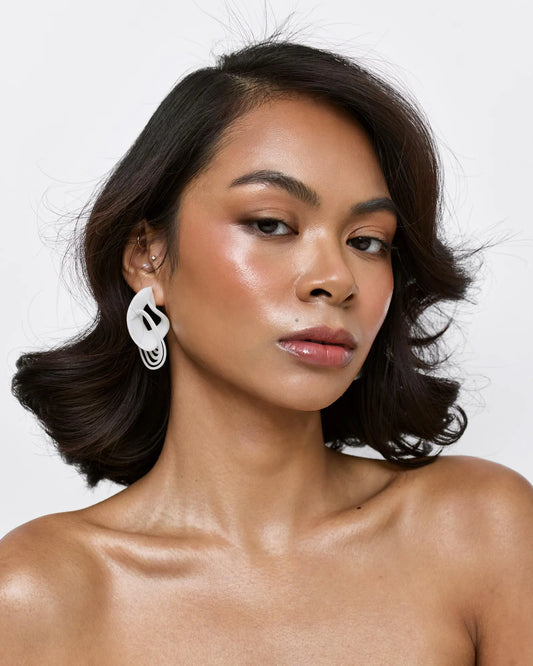 Model wearing white accessories jewelry, showing the infinity loop scale.