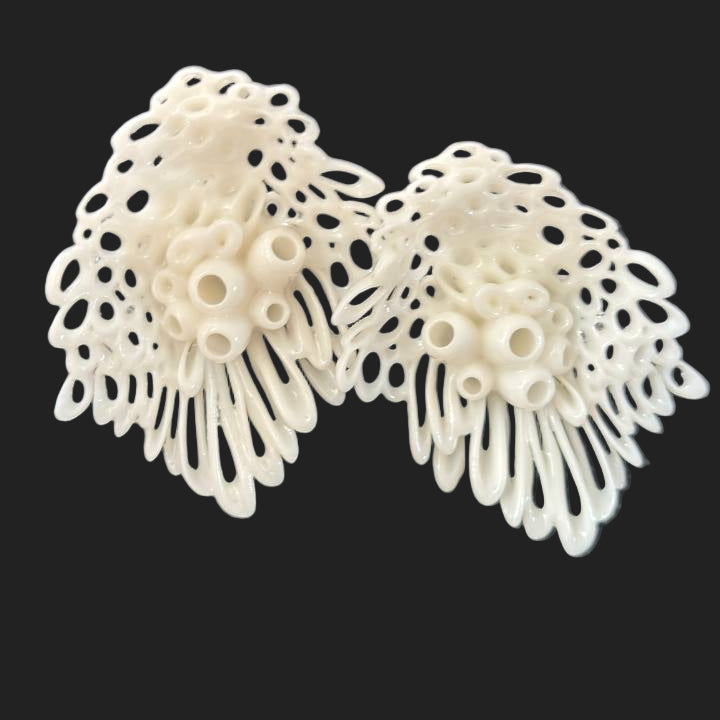 Pair of white lace earrings on a dark background