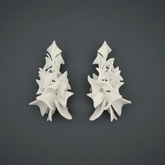 Bold statement earrings (Petal Cascade) product photo, showing the full sculptural shape on a dark background.