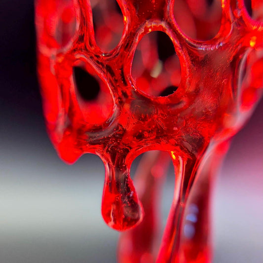 Close-up of red earrings on a gradient background.