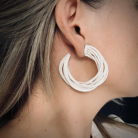 Profile view of model wearing lightweight large statement earrings.