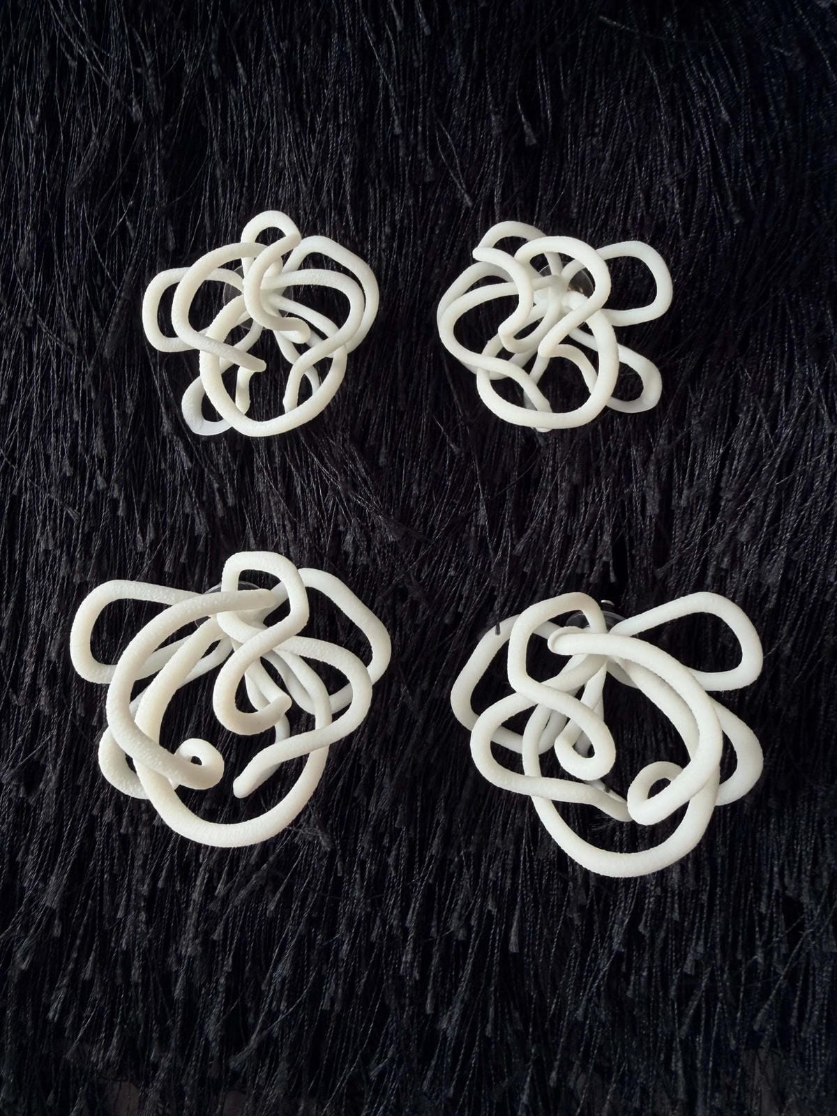 Abstract white sculptural jewelry pieces on black textured background, Eclipse Element