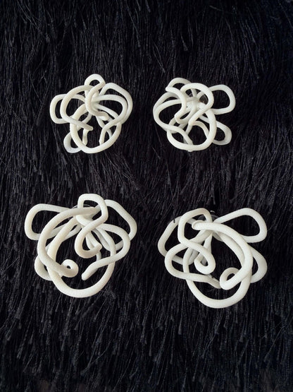 Abstract white sculptural jewelry pieces on black textured background, Eclipse Element