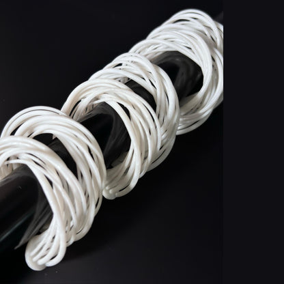 A white 3D printed Swirl Hoop Earring, displayed on its side, highlighting the layered strands against a black background.