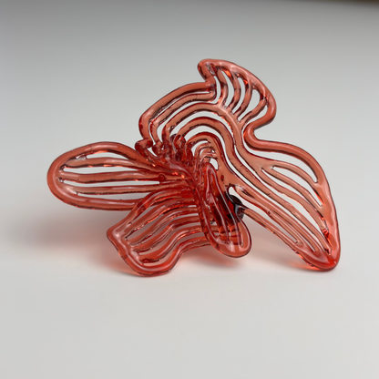 Red butterfly-shaped 3d printed earring on a light gray background