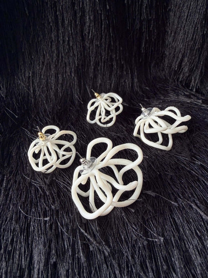 Sculptural white earrings on black textured background, Eclipse Element handcrafted jewelry