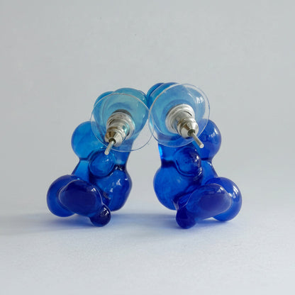 Pair of blue and clear glass earrings on a light gray background