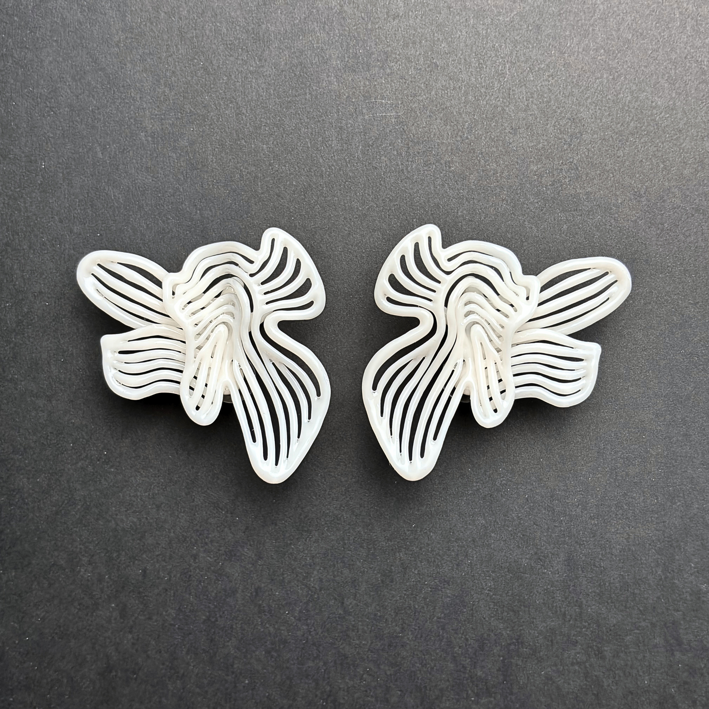 Butterfly-shaped earrings on a dark gray background