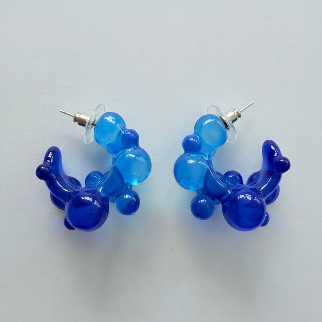 Pair of blue balloon-shaped earrings on a light gray background