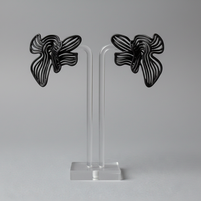 Pair of gold butterfly-shaped earrings on a white stand against a white background