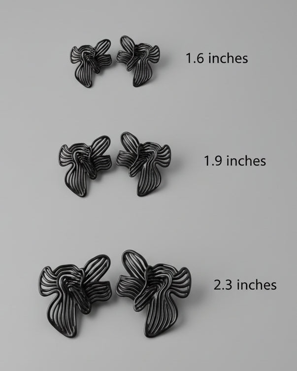 Pair of black butterfly-shaped earrings on a light grey background