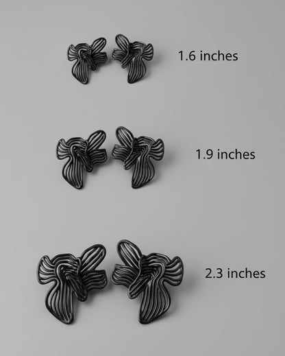 Pair of black butterfly-shaped earrings on a light grey background