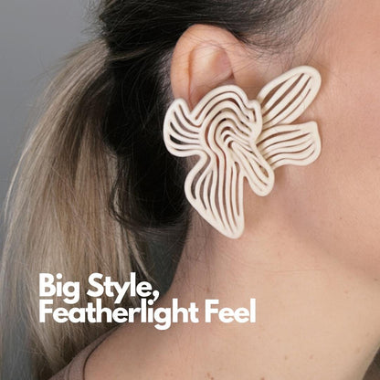 Close-up of a model's ear, showcasing a large beige 3D printed Rhythm Earring with a "Big Style, Featherlight Feel" overlay tag.