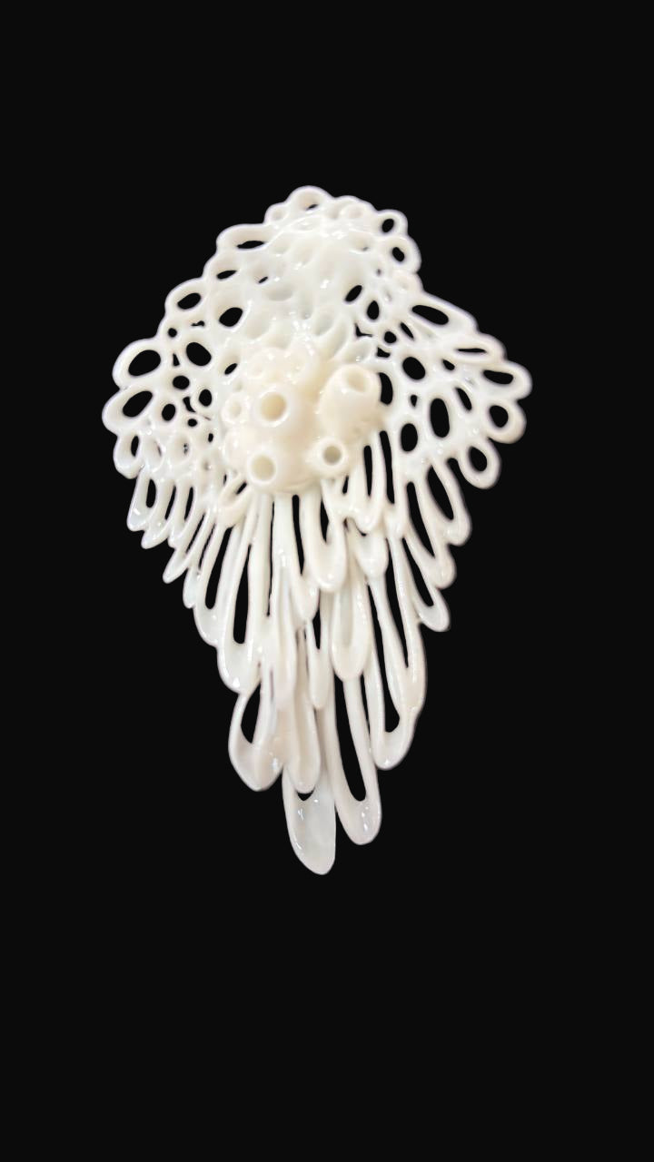 White lace-like 3d printed earring on a black background