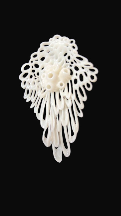 White lace-like 3d printed earring on a black background