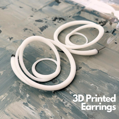 White sculptural swirl hoops 3D printed recycled resin on a textured background