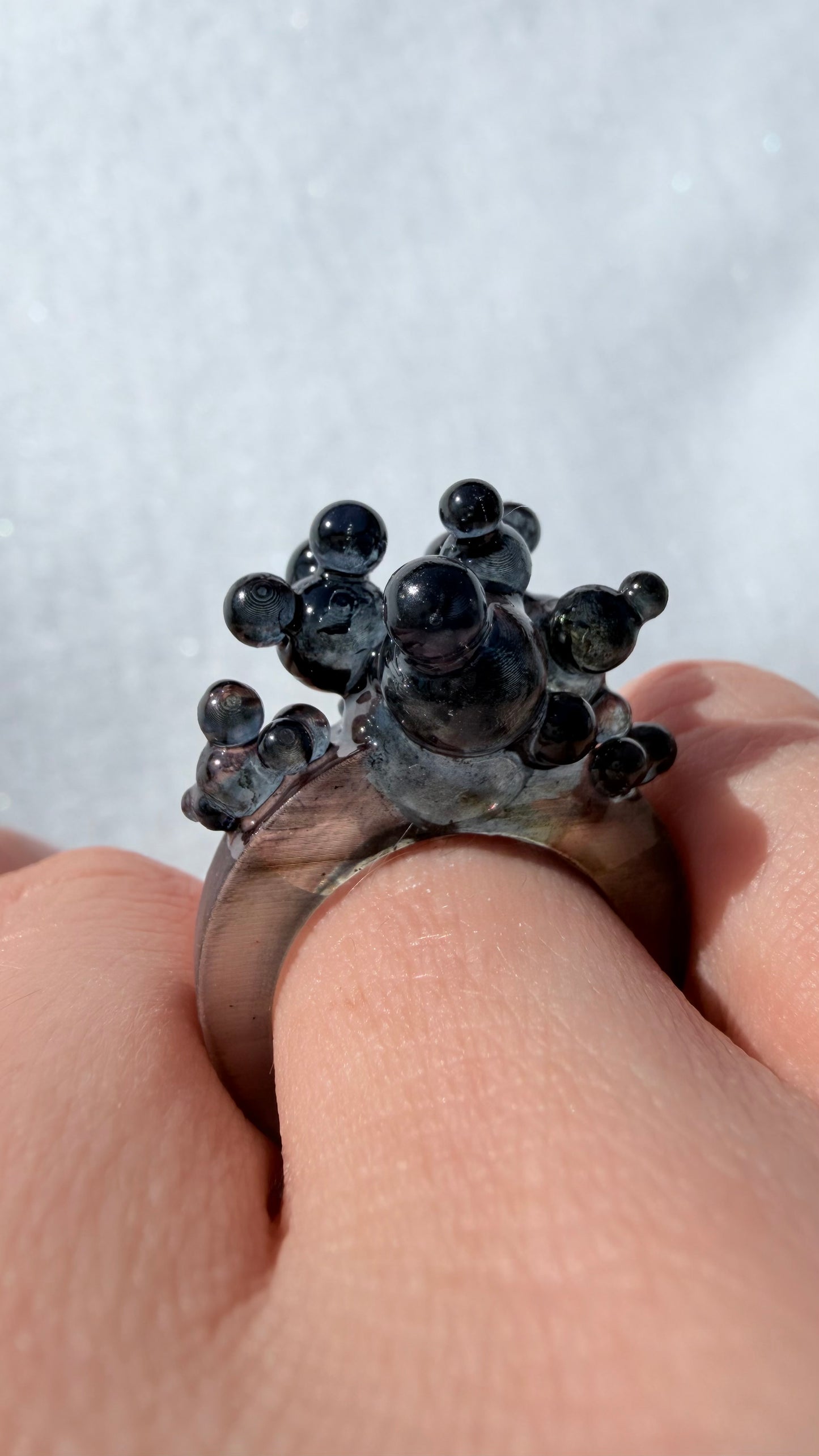 Model wearing a chunky sculptural ring, showcasing its scale and edgy fashion jewelry style.