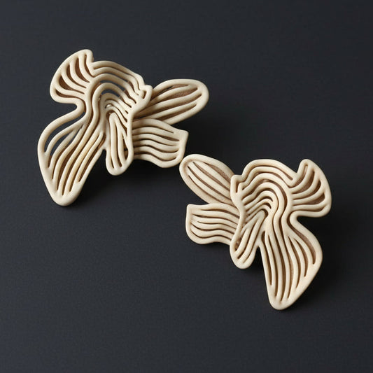 Pair of beige floral earrings on a black background