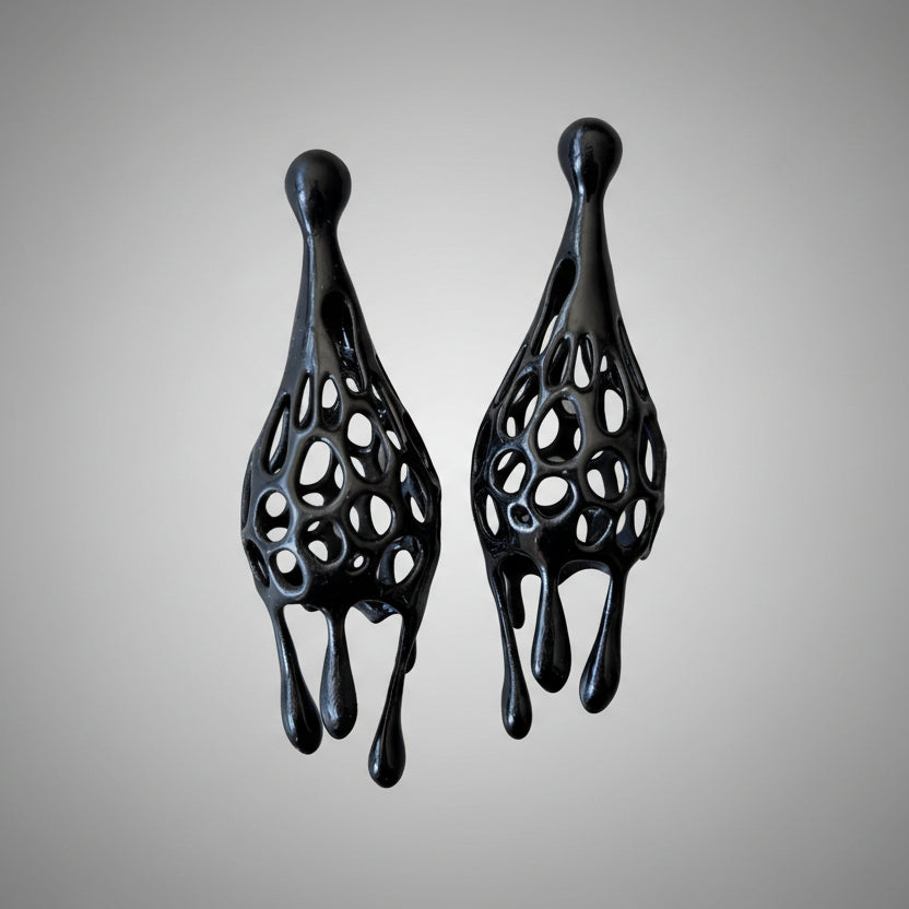 Pair of black fashion jewelry drip earrings on a white background.