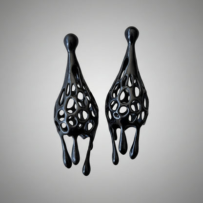 Pair of black fashion jewelry drip earrings on a white background.