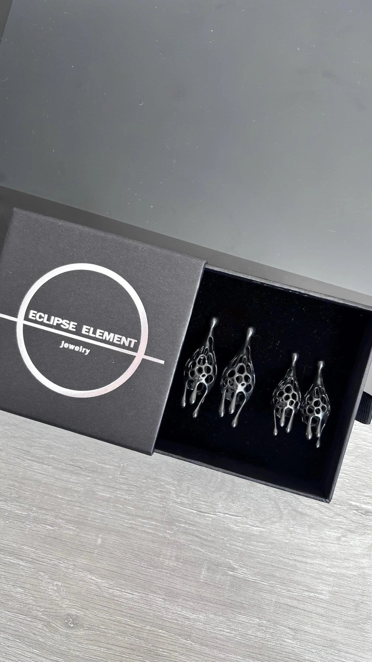 Black fashion jewellery aesthetic earrings in premium branded packaging.