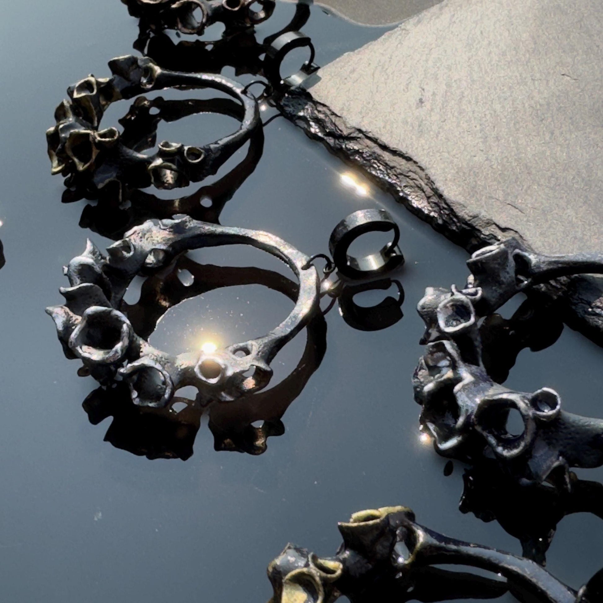 Close-up of black hoop earrings on a dark surface.