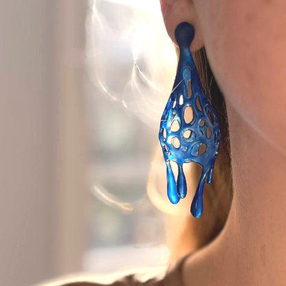 Blue liquid-like earring on a person's ear.