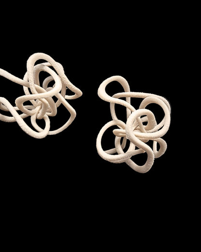 celecial loop , beige 3d printed earrings on black background

