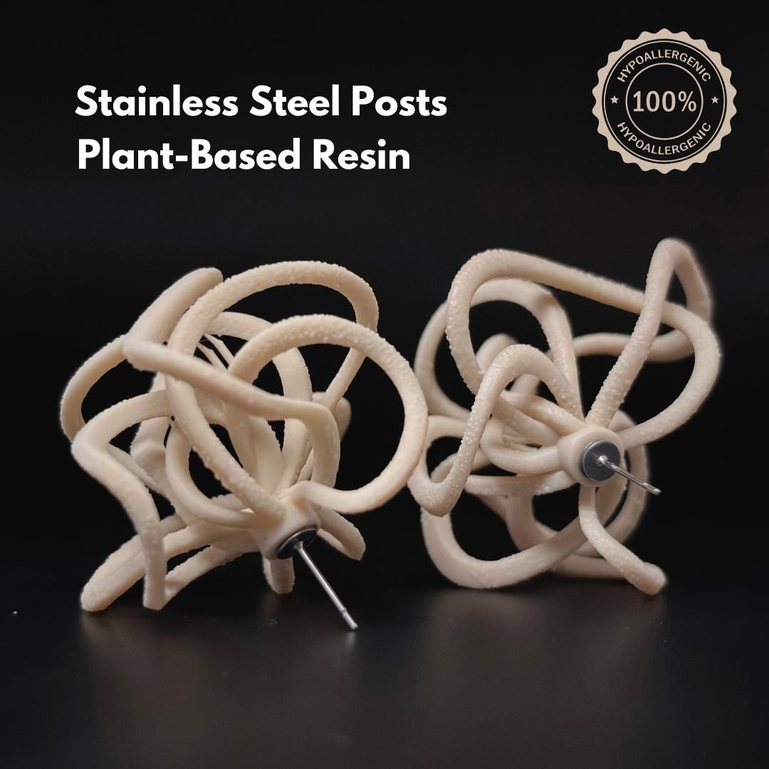 Pair of Ivory Celestial Loops on black background with text: Stainless Steel Posts, Plant-Based Resin