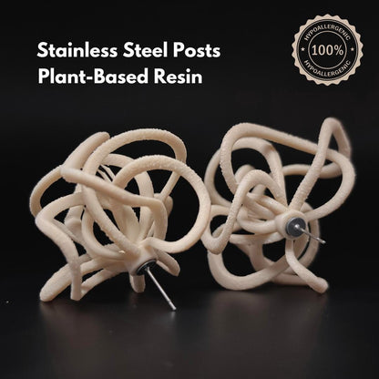 Pair of Ivory Celestial Loops on black background with text: Stainless Steel Posts, Plant-Based Resin