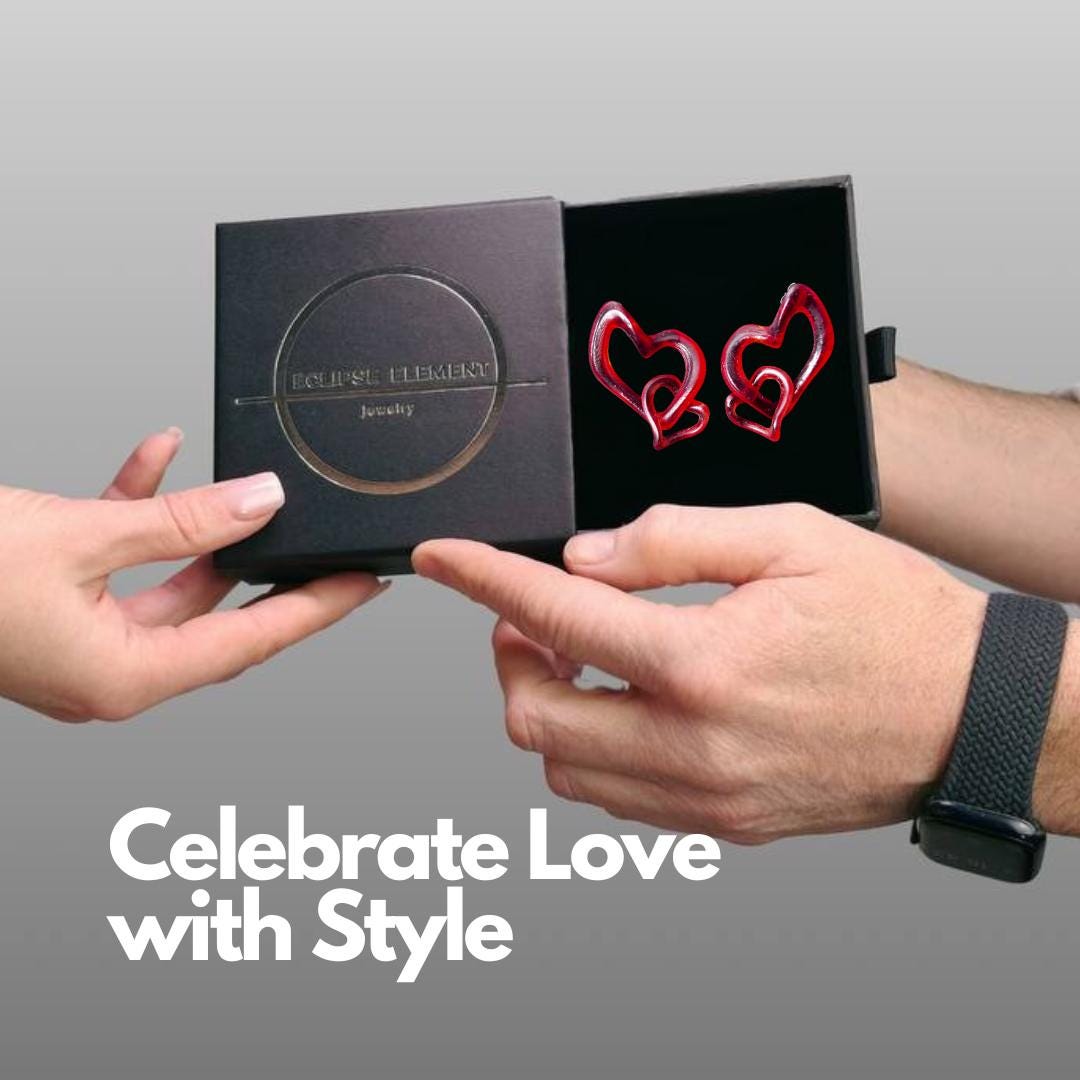 Heart-shaped earrings in a black box held by two hands with a text overlay 'Celebrate Love with Style'.
