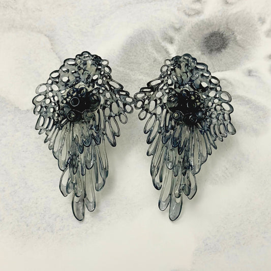 Pair of black Coral Lace earrings on white textured background, main product shot