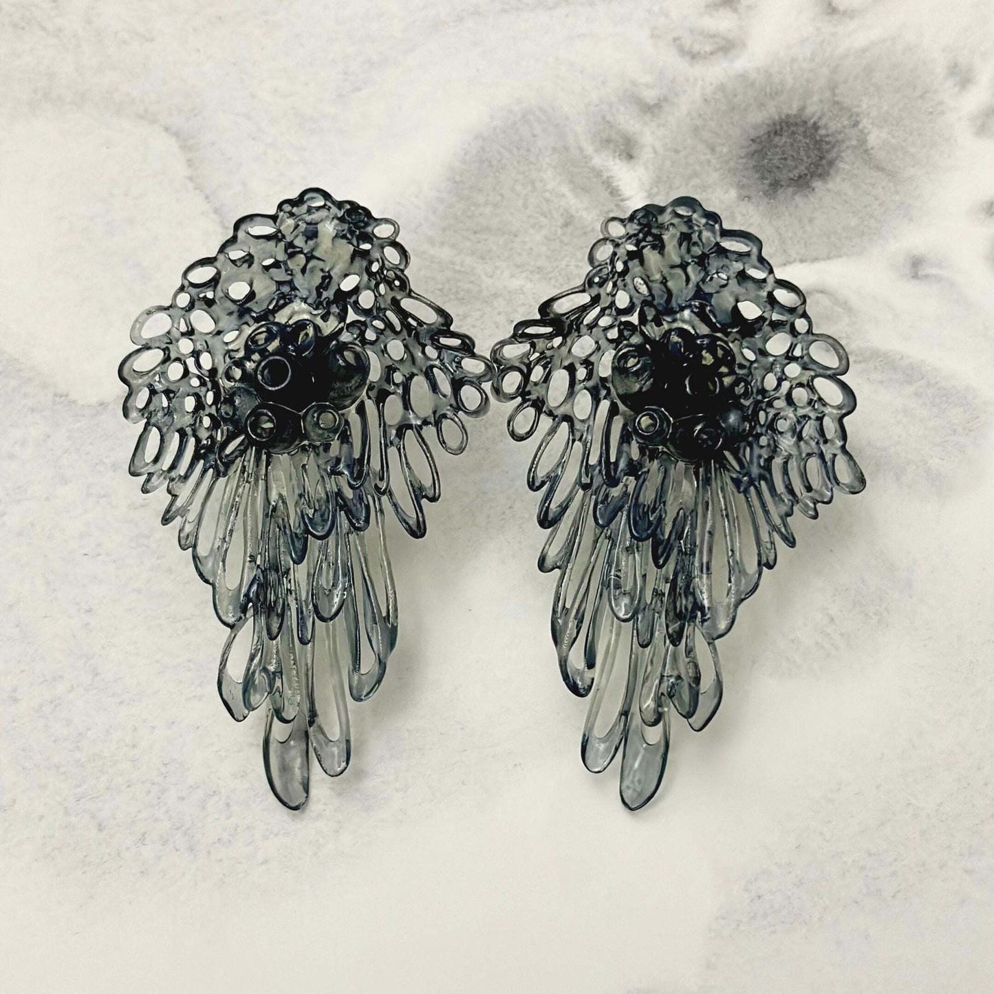 Black fashion jewelry coral lace earrings on a neutral background.