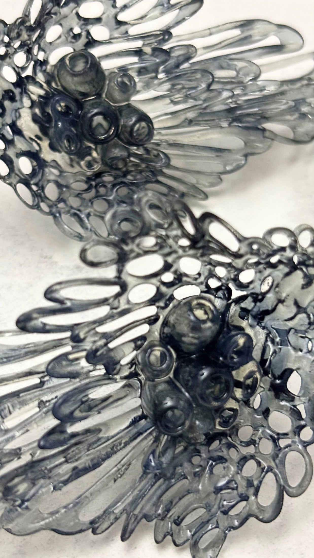 Detailed view of the organic coral-like holes in the sculptural earrings.