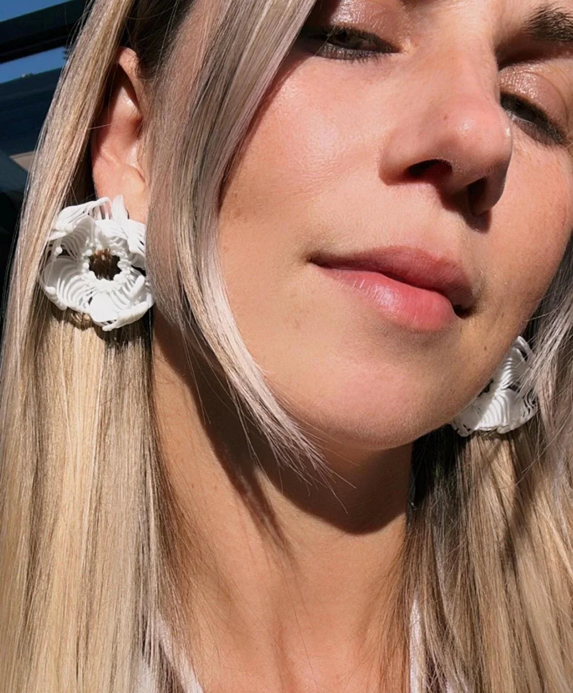 White flower earring worn by model, perfect for a bridesmaid fashion jewelry look.