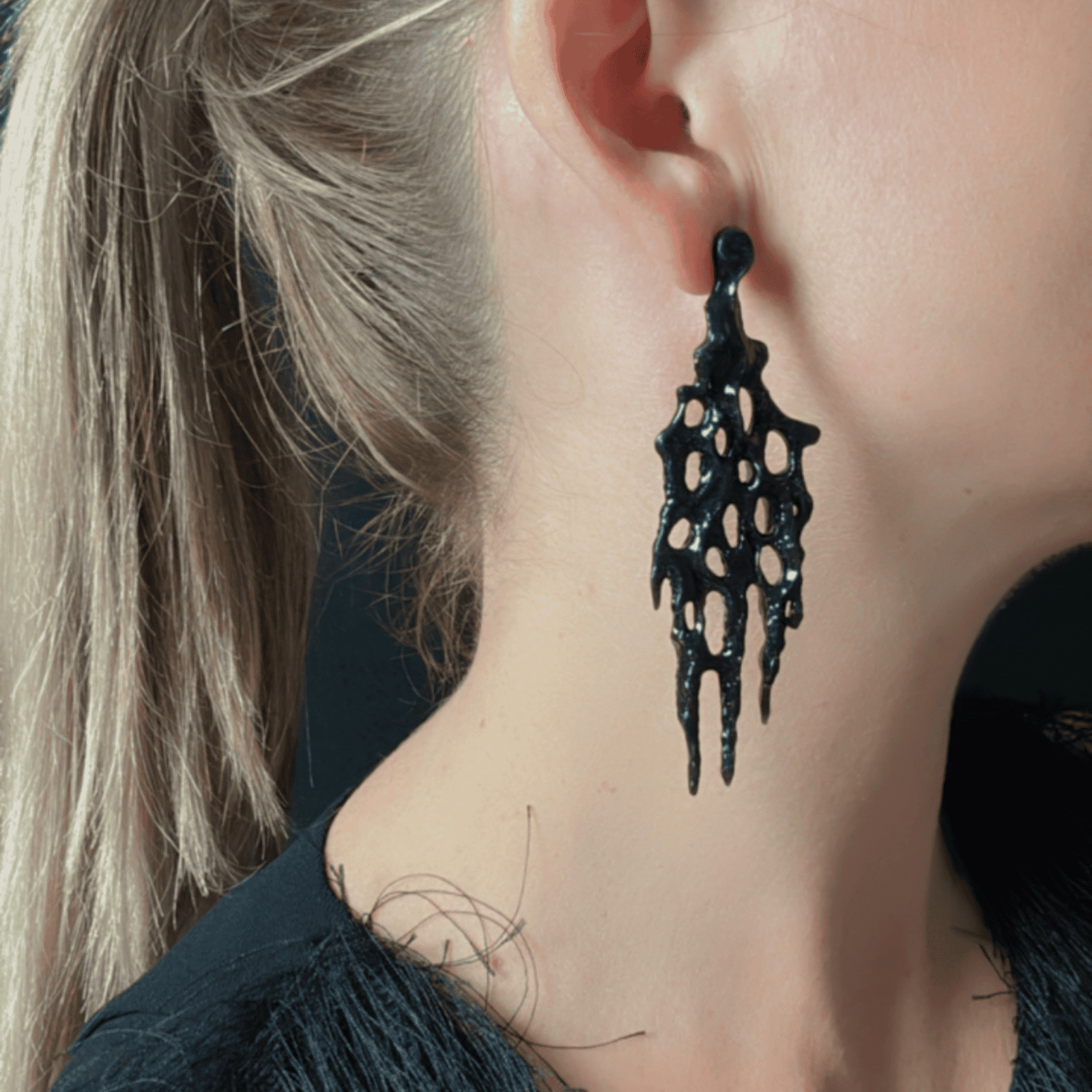 Close-up of goth earrings on model, showing the texture and detail near the face.
