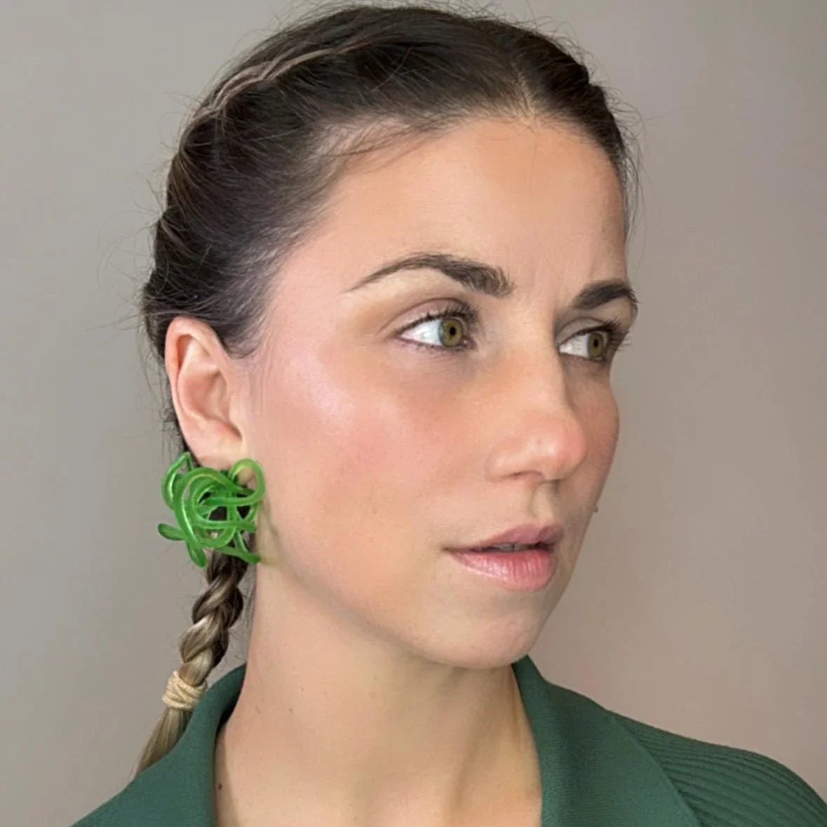 Profile view of model with teal colored fashion jewelry style green loops.