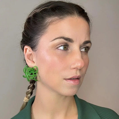 Profile view of model with teal colored fashion jewelry style green loops.
