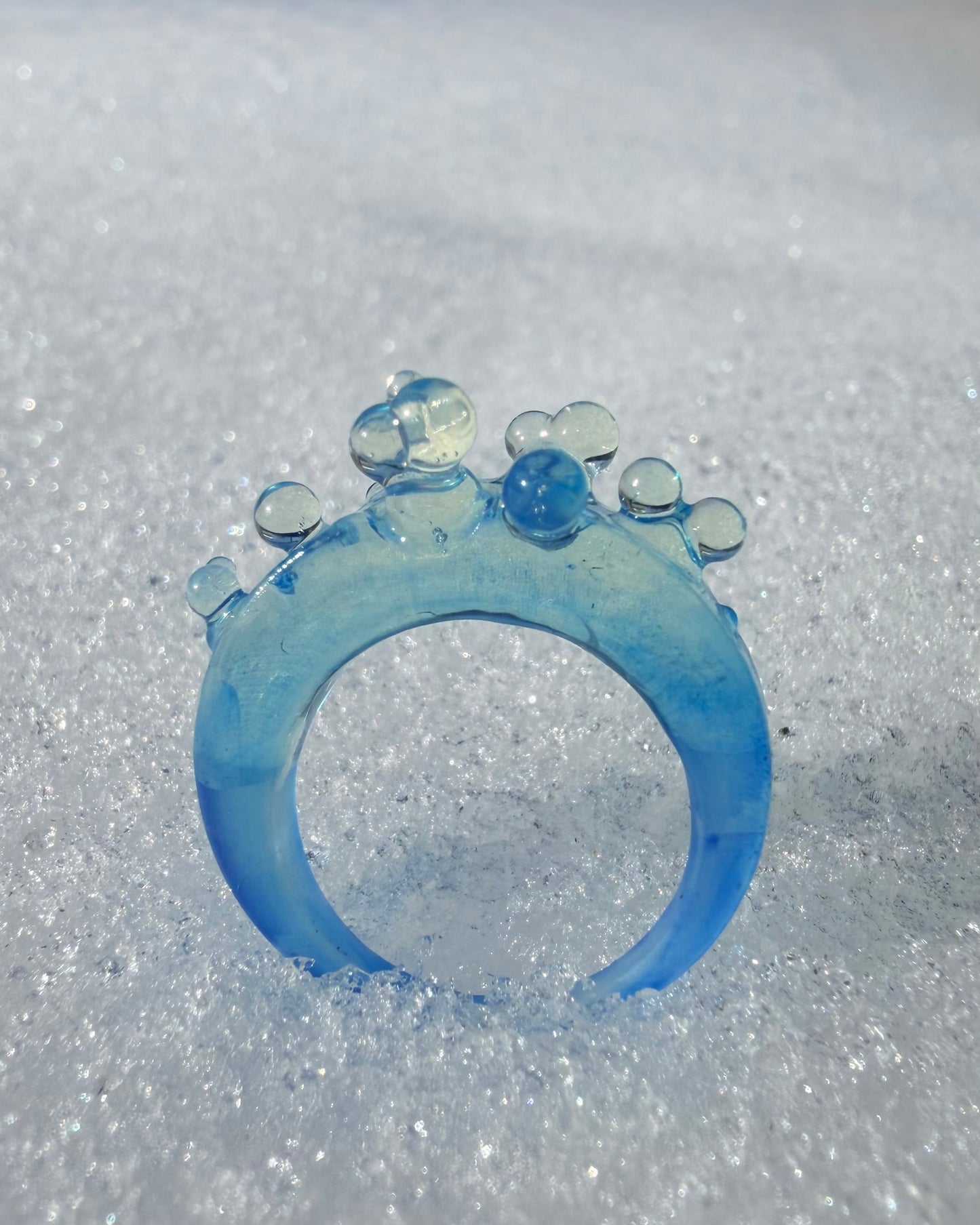 Front view of the Ice Blue Bubble Ring on a white background, showcasing its sculptural spheres and vibrant azure tone.
