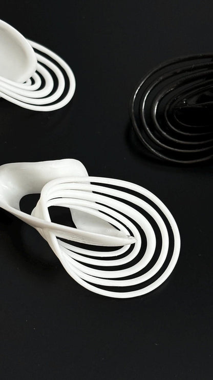 Black and white costume jewelry loops shown against a dark backdrop.