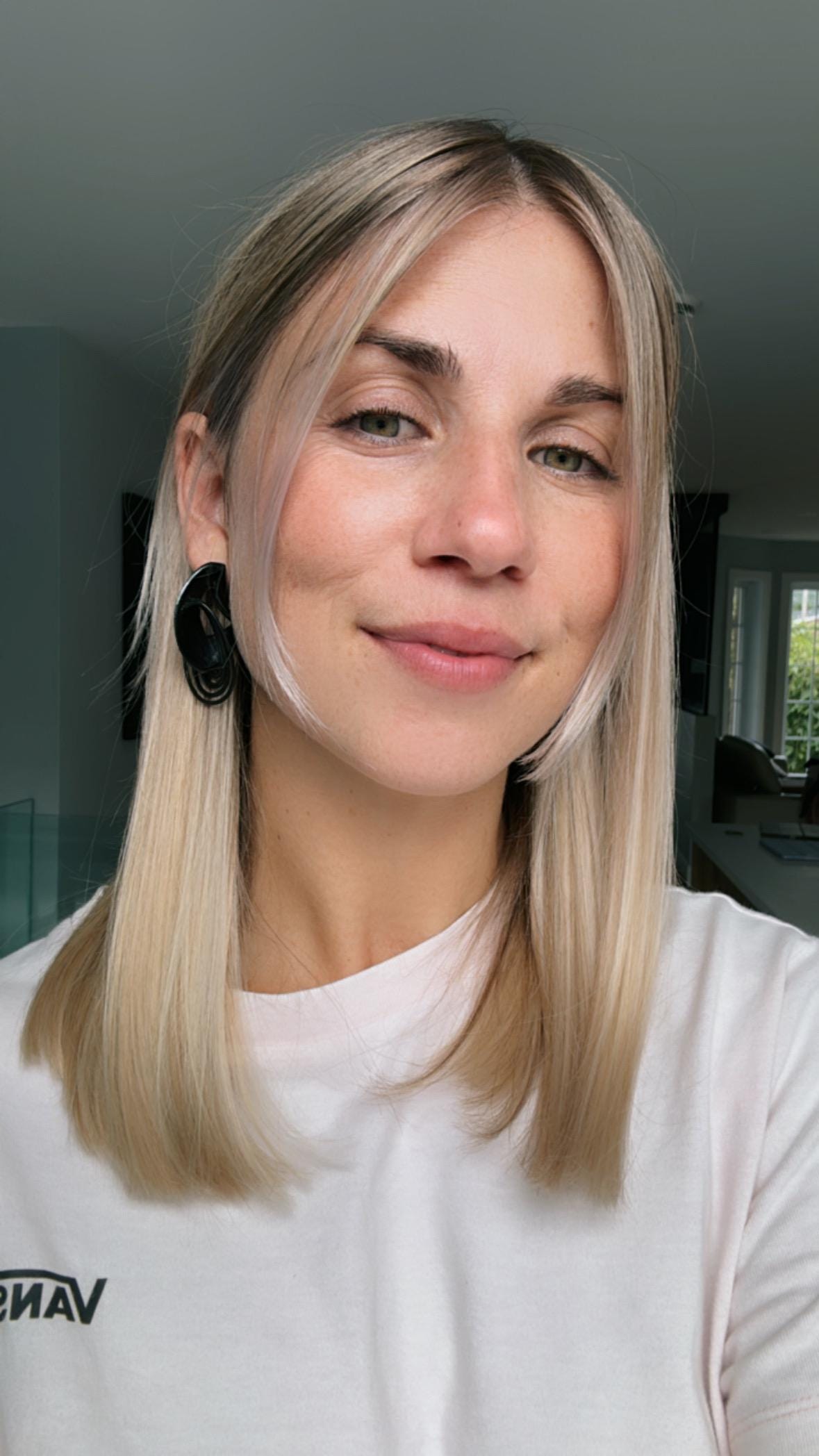Bold statement earrings in black shown on the model.