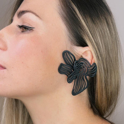 Woman wearing a large black floral earring