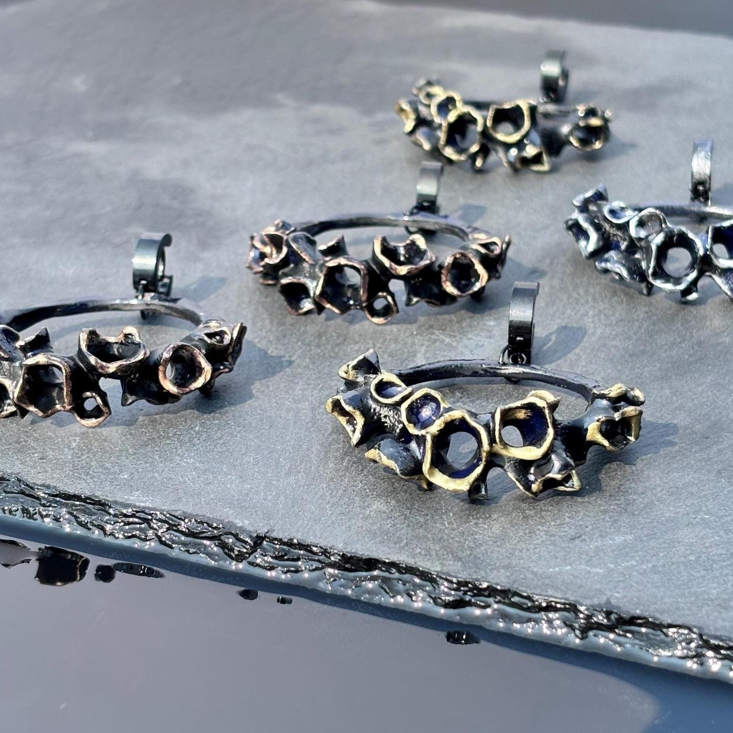 Collection of large black hoop earrings on a textured surface