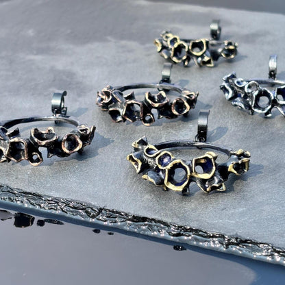Collection of large black hoop earrings on a textured surface