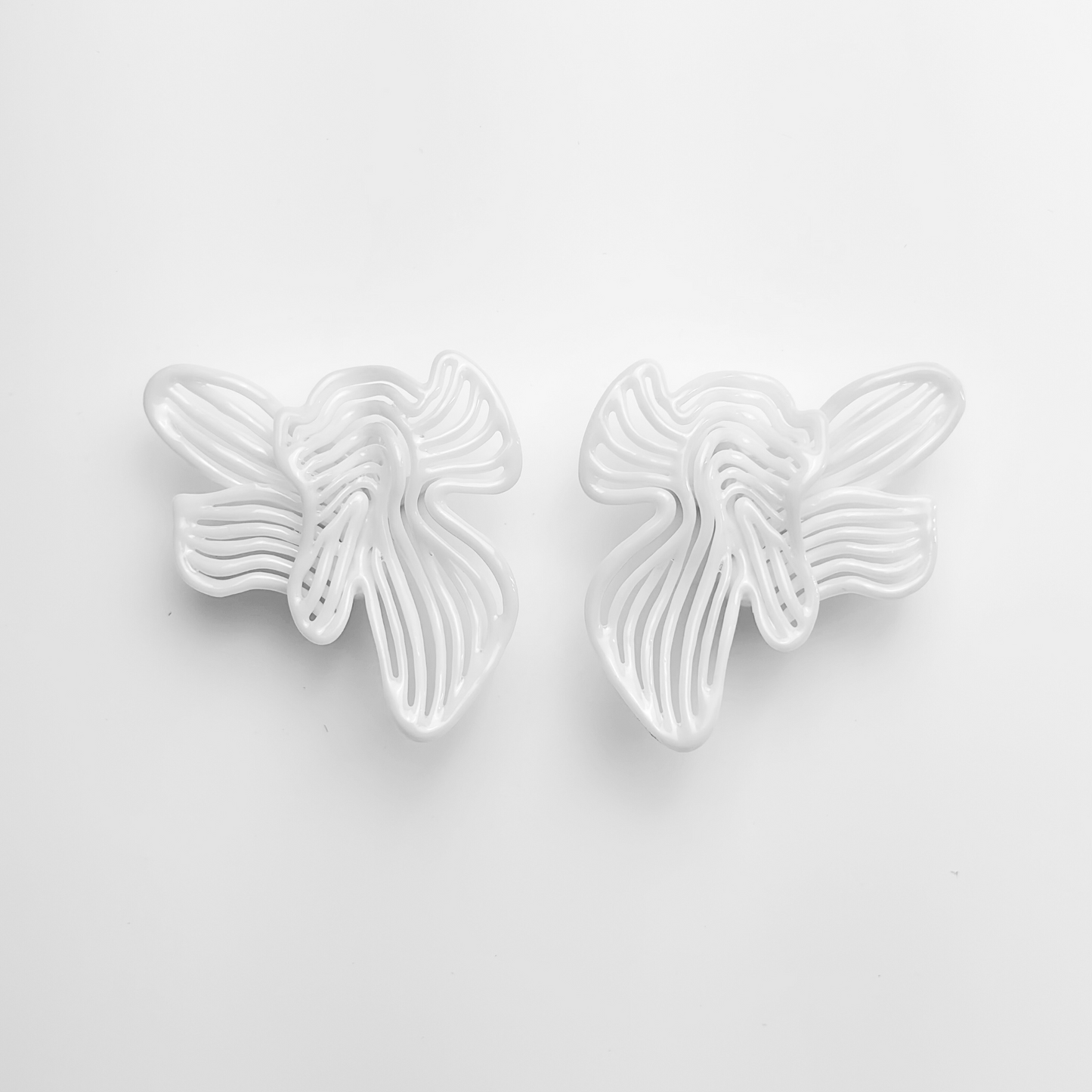 White large white floral statement earring on a light gray background