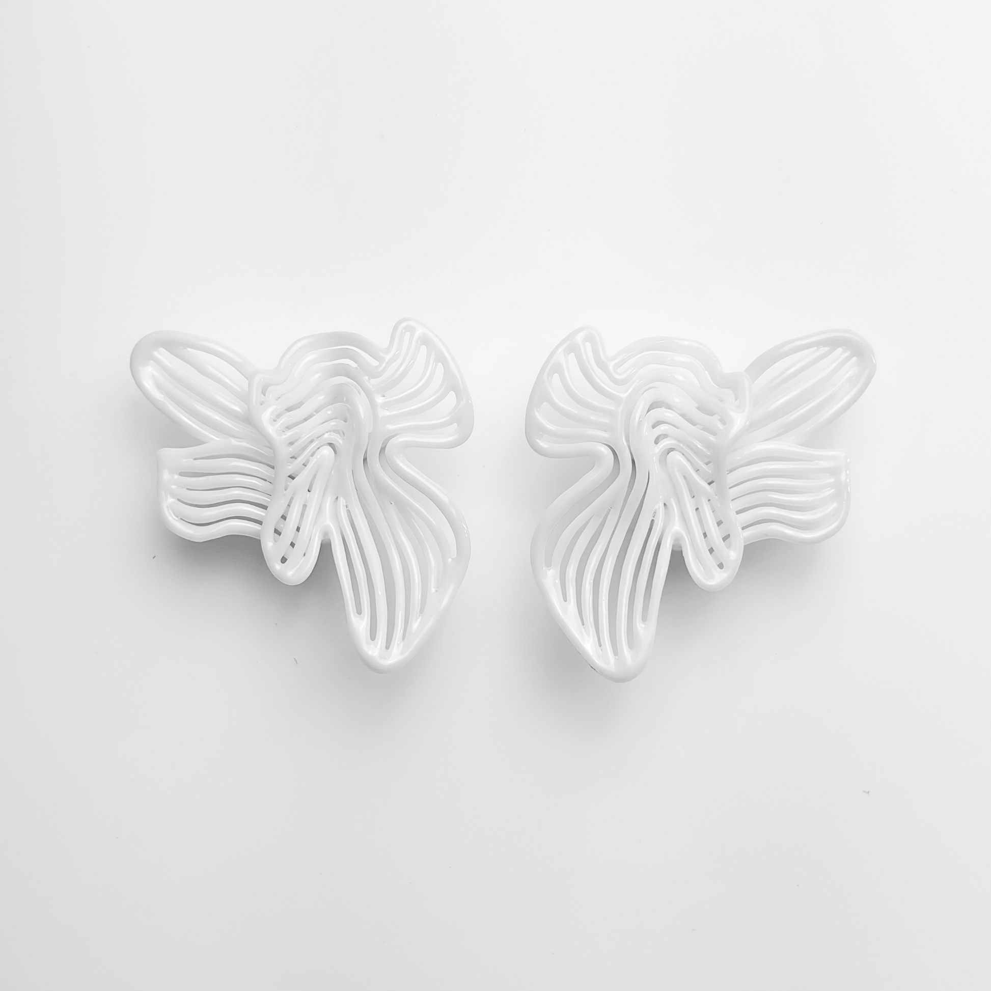 White large white floral statement earring on a light gray background