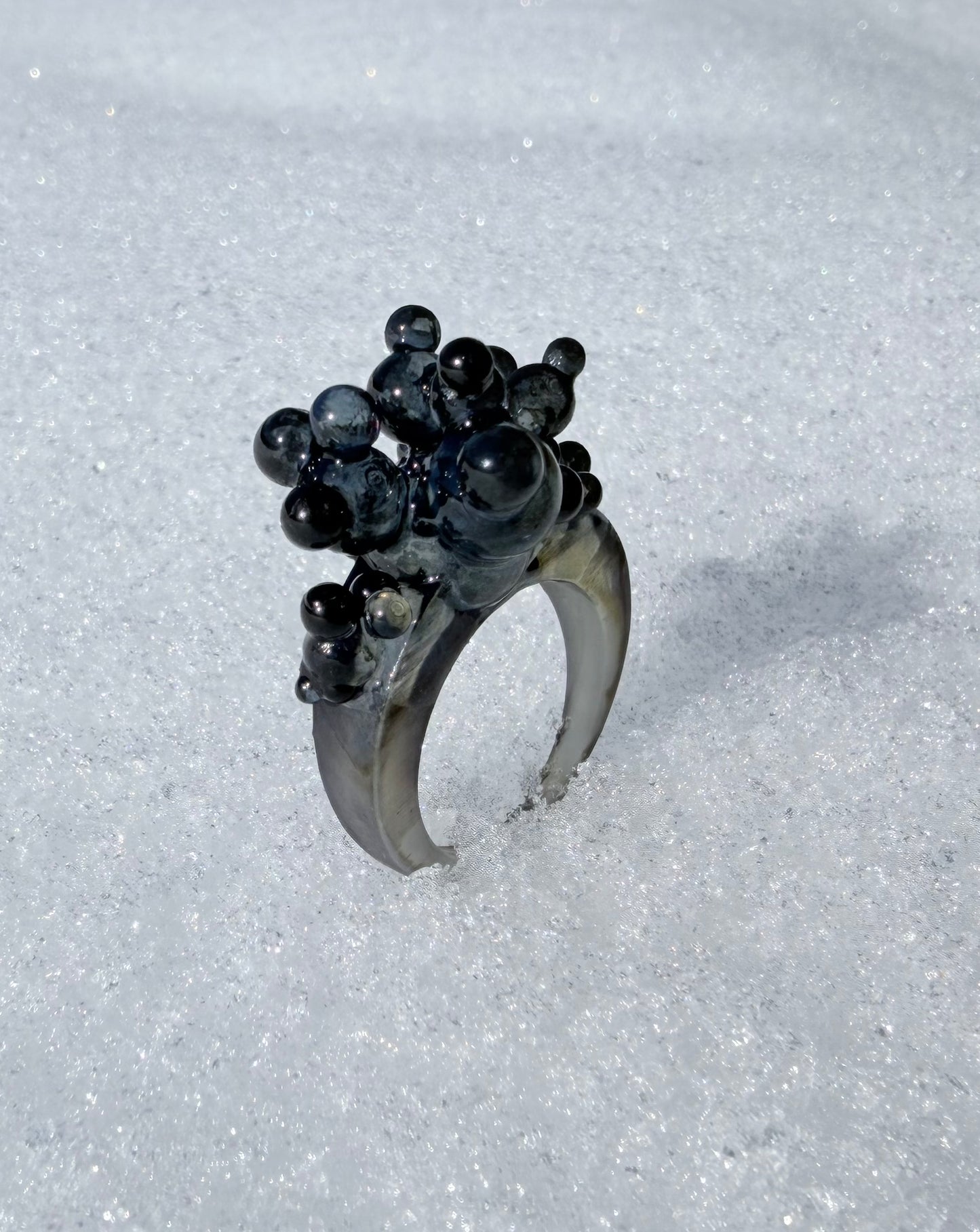 High-fashion styling with a black architectural ring, perfect for gallery openings or artistic events